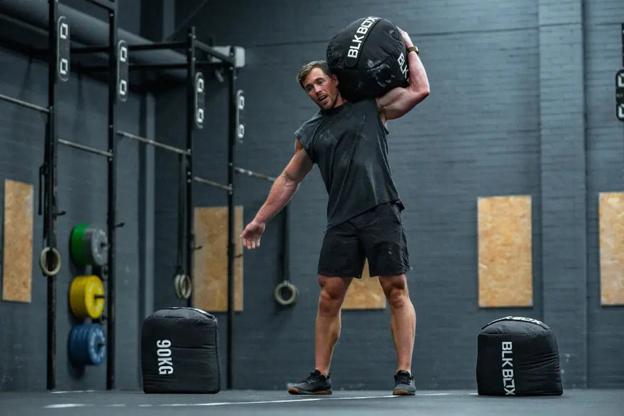 From Carries to Cleans: Unlocking the Power of the Strongman Sandbag - BLK BOX